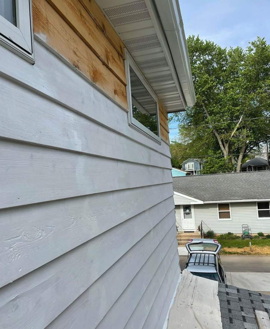 A close view of new wood siding with a coat of primer