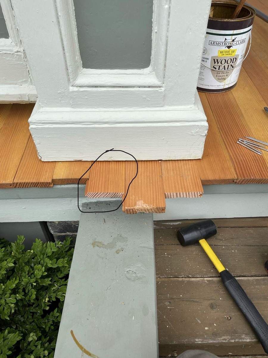 A cut line marked in pencil on a floorboard beside a column base