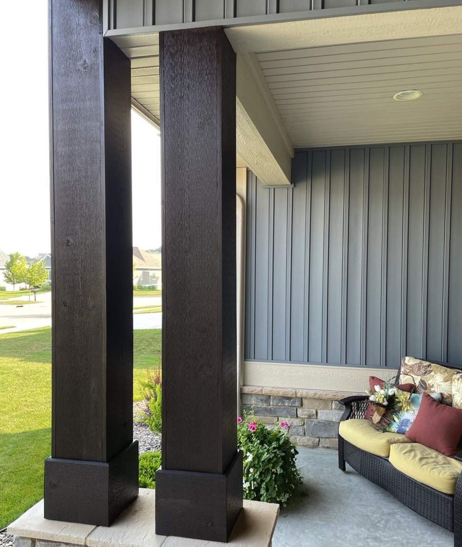 Dark stained wood porch columns on stone bases