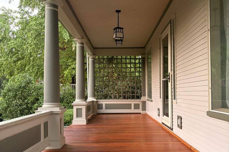 The finished porch seen down its length, with a hanging lantern, round columns and a stained floor