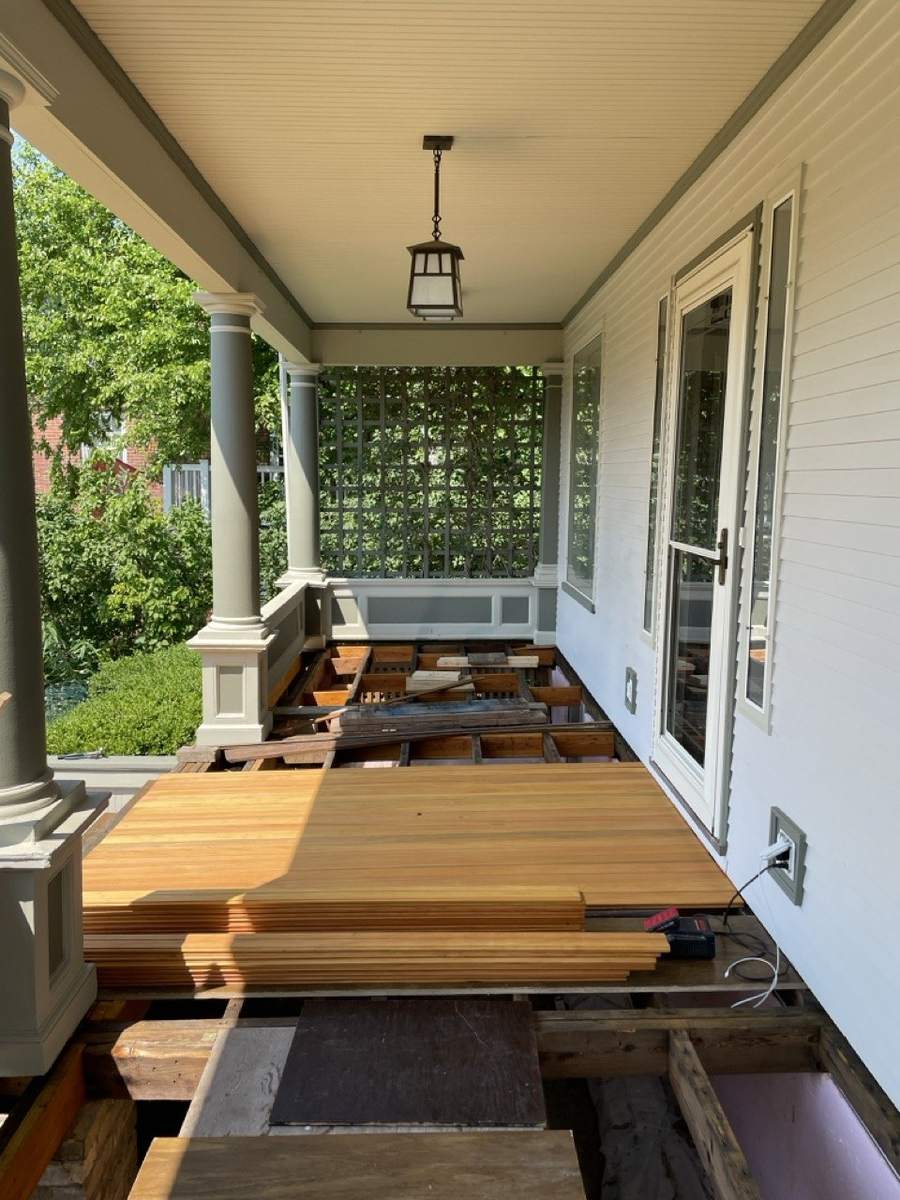 The first new boards laid along the porch, under a hanging lantern