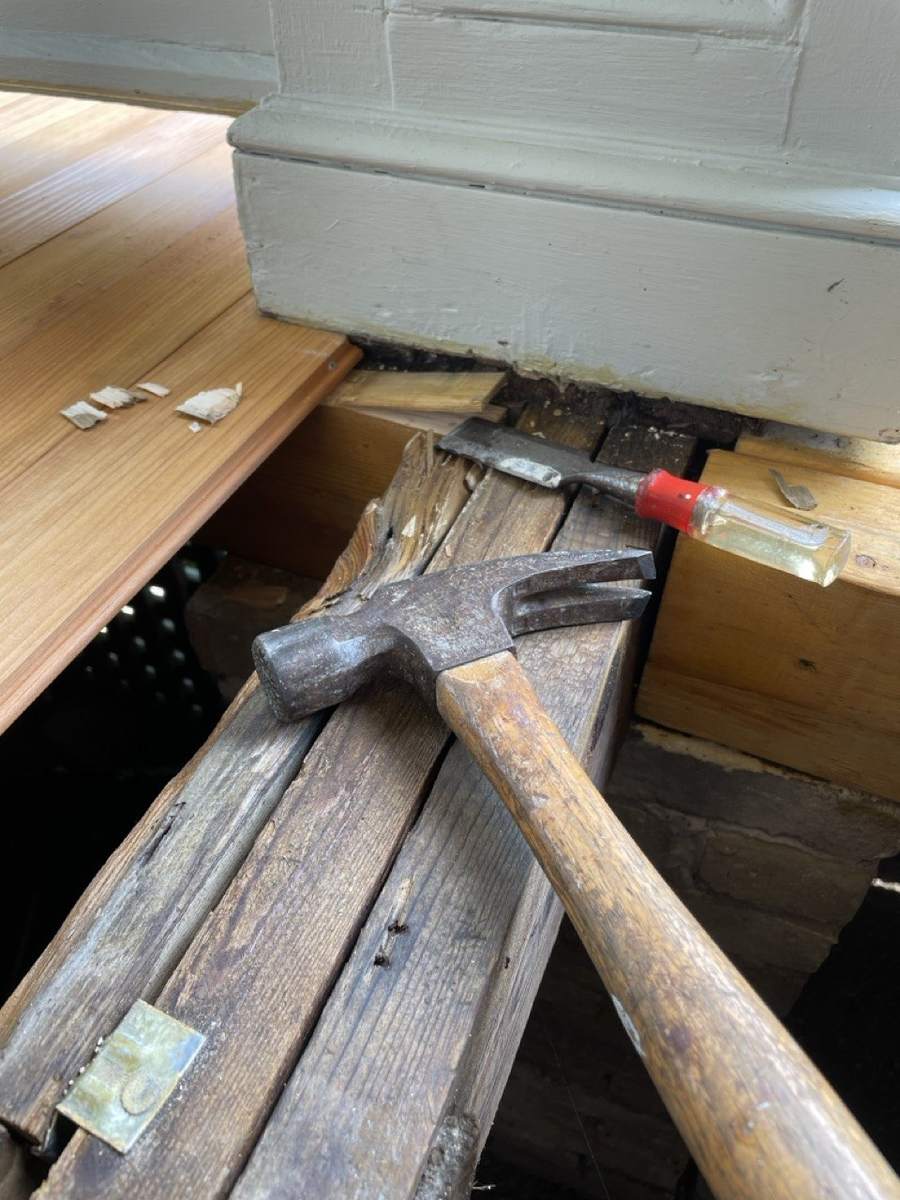 A hammer and chisel at the base of a column