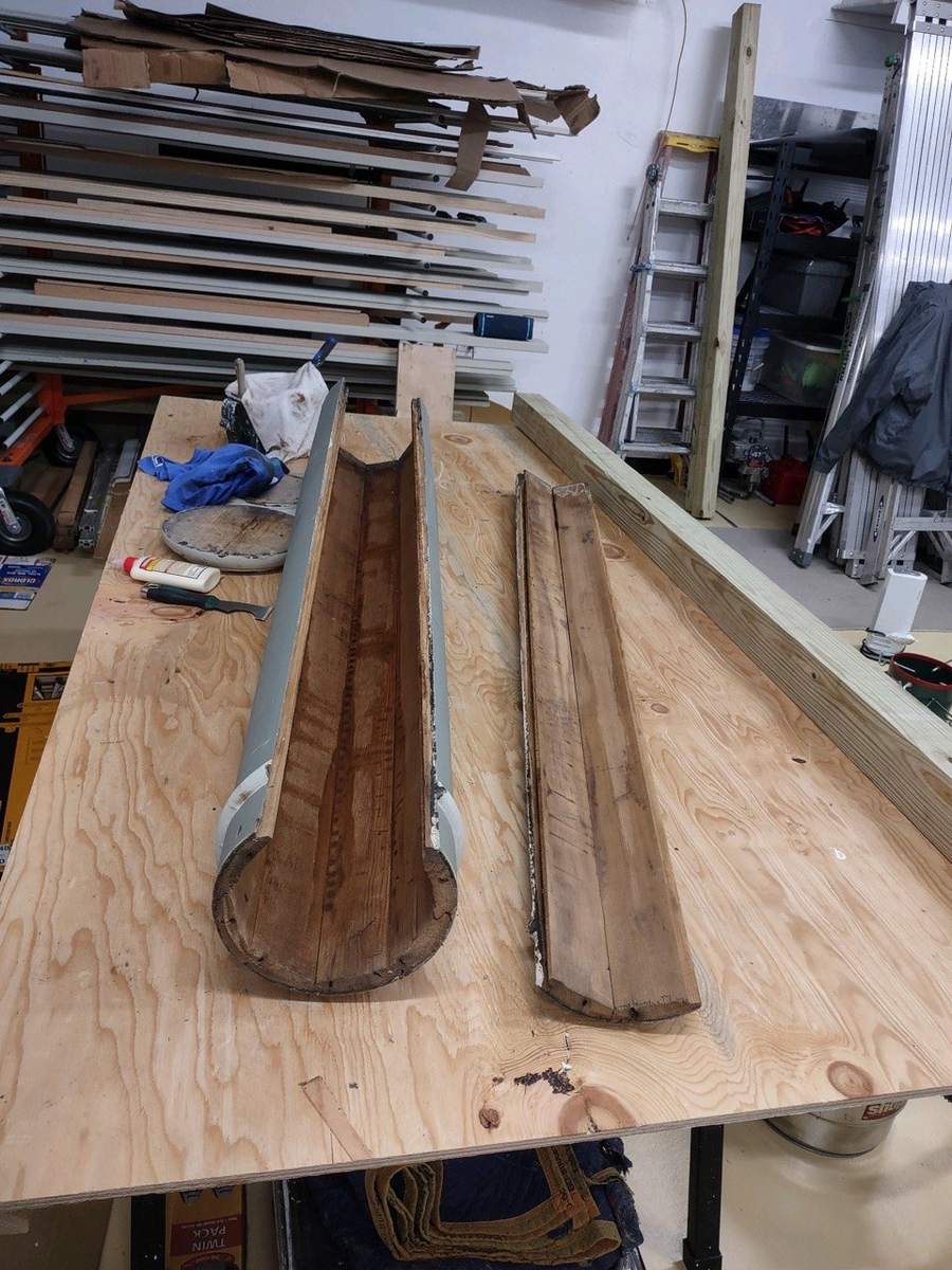A hollow wood column split open on a workbench