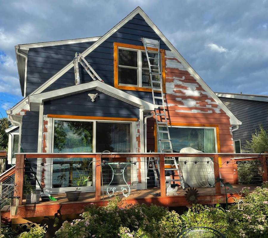 A house partway through repainting, navy on the left and the old color on the right