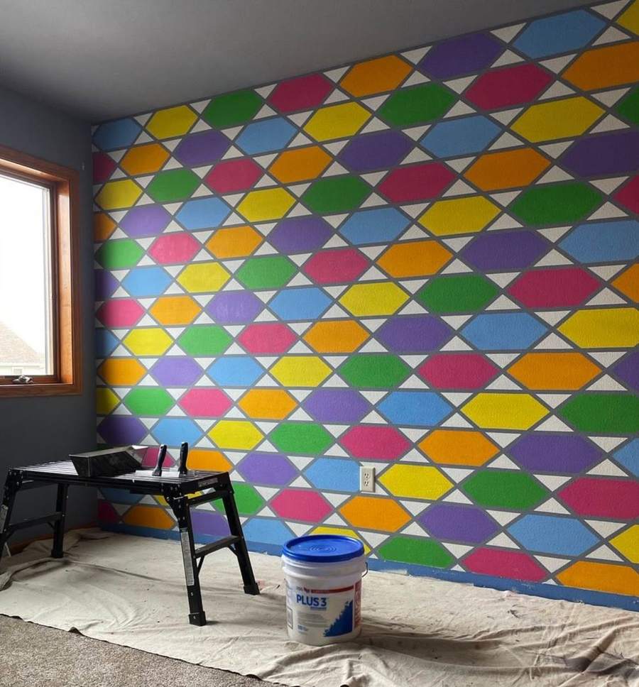 An interior wall painted in a pattern of multicolored hexagons