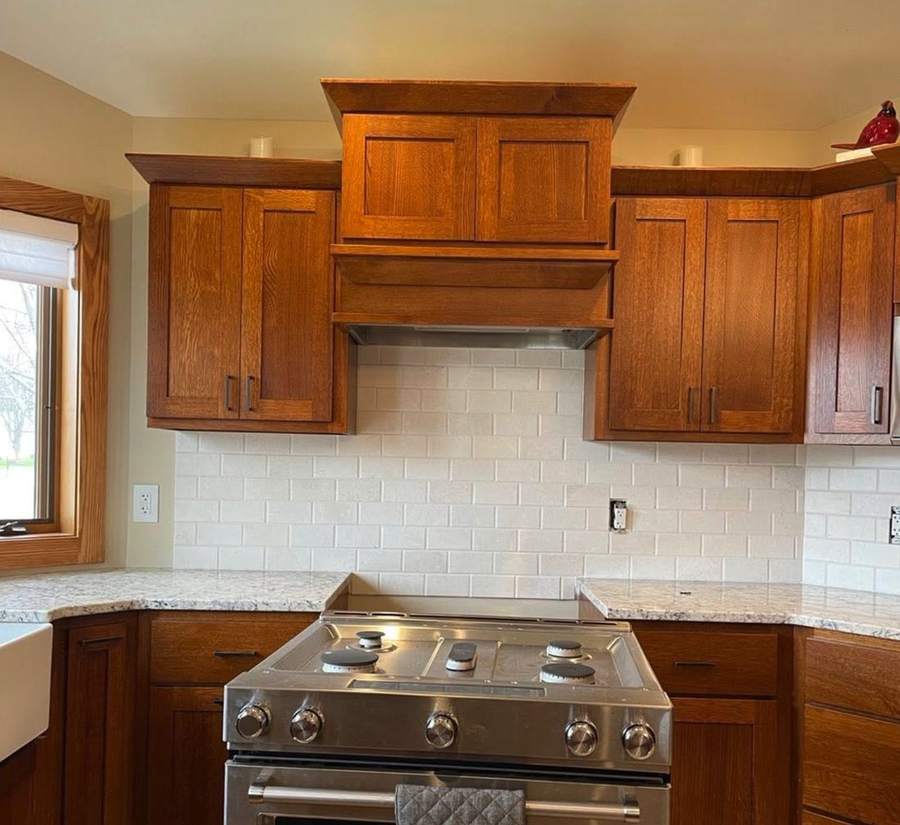 Kitchen with warm oak cabinets and a new tile backsplash