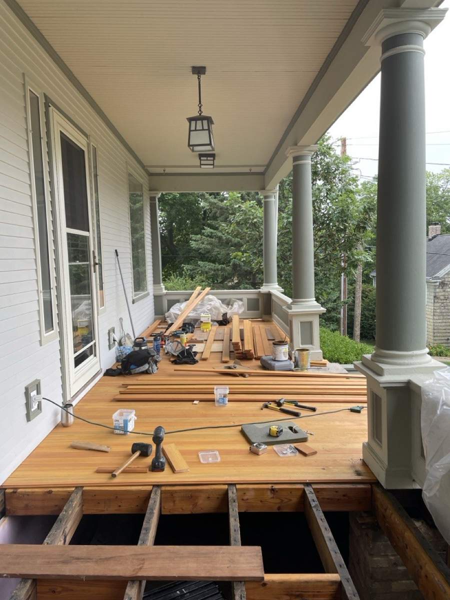 Most of the porch floor laid, with tools on the boards