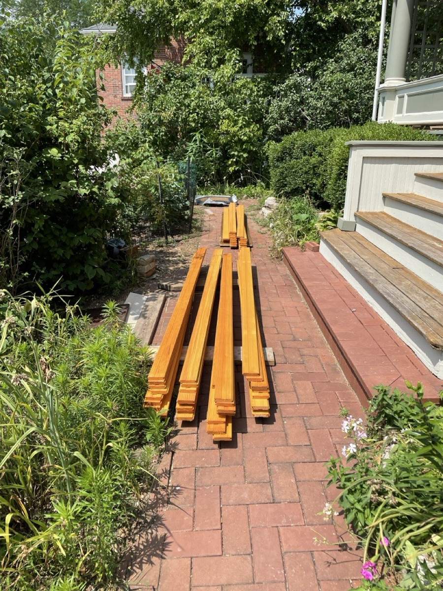 New flooring boards laid out on a brick path