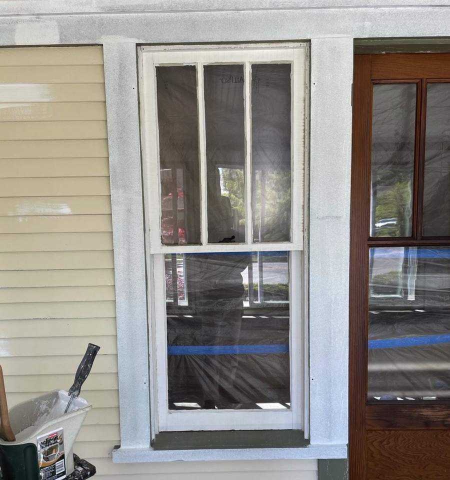 An old double-hung window with the sash and trim primed