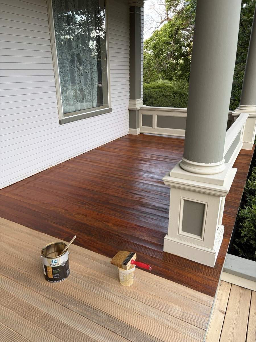 Stain being applied, with bare boards in the foreground