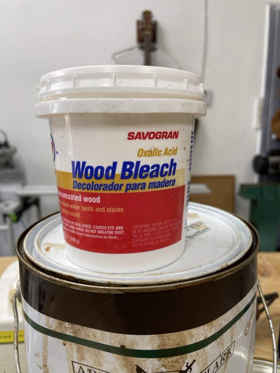 A tub of wood bleach on a workbench